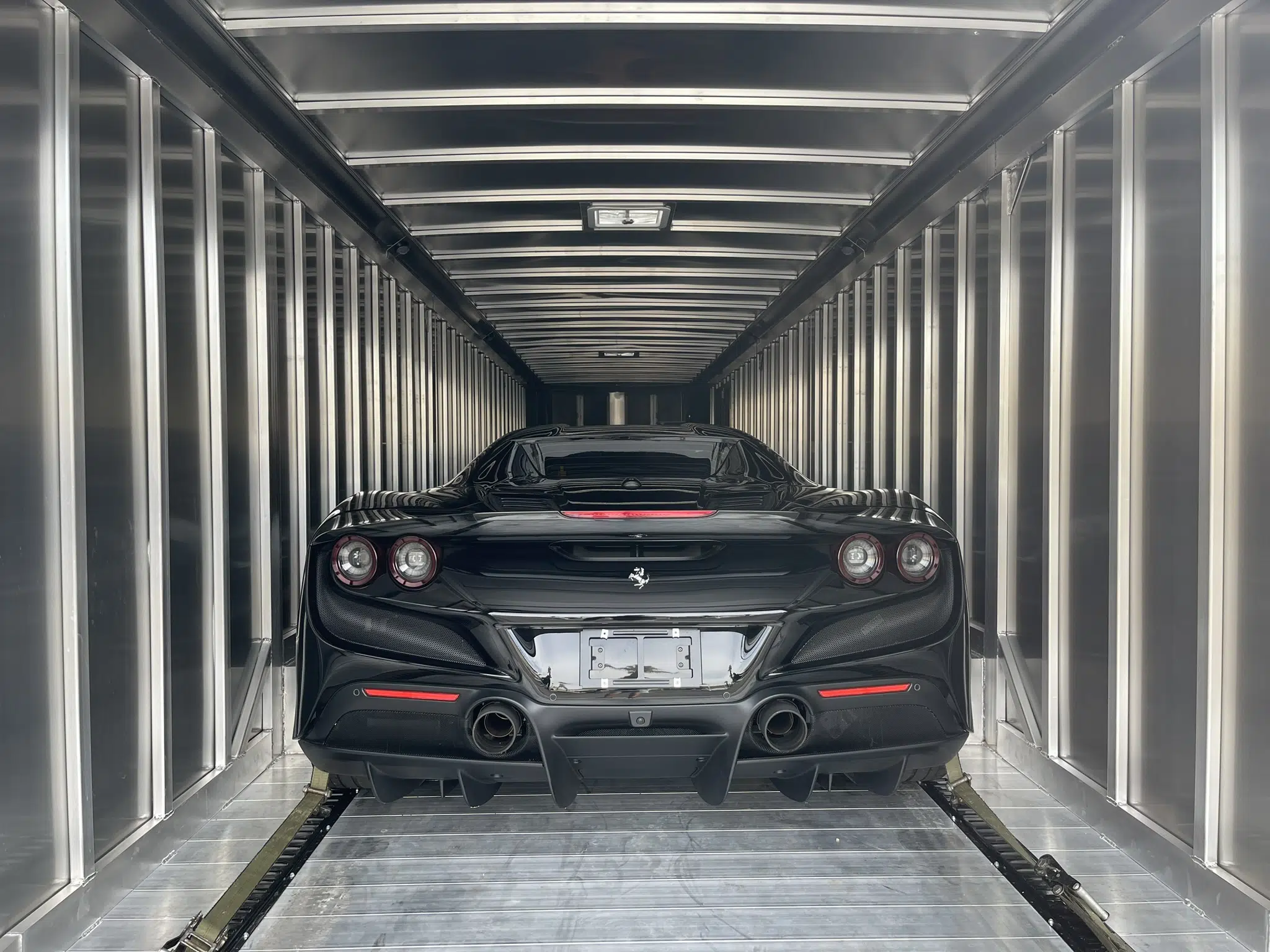 A black sports car inside an Enclosed Car Transporter- Luxury Auto Transport