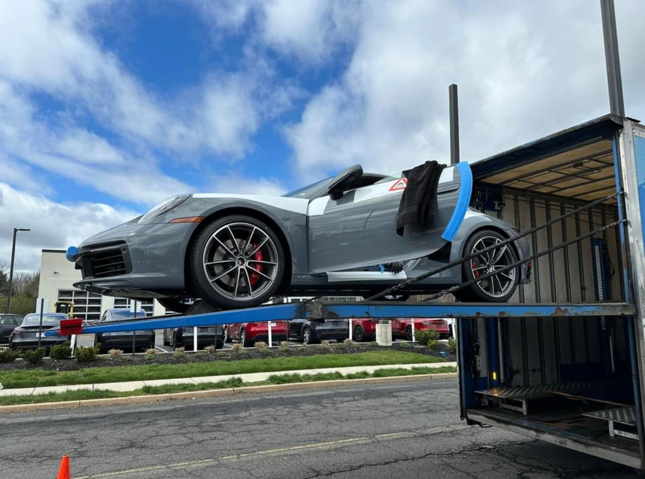 A truck is being loaded with a car, illustrating the process of vehicle transportation and logistics.